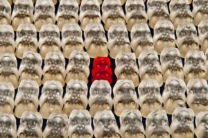 One red gummy bear amongst a sea of white